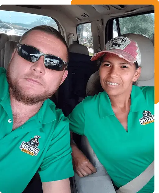 Western Wildlife Control team members in their company truck with a humanely trapped raccoon